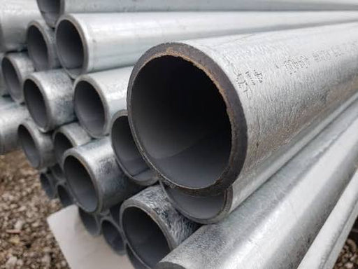 A close-up view of stacked galvanized steel pipes, showing their metallic silver-gray exterior and dark interior openings.